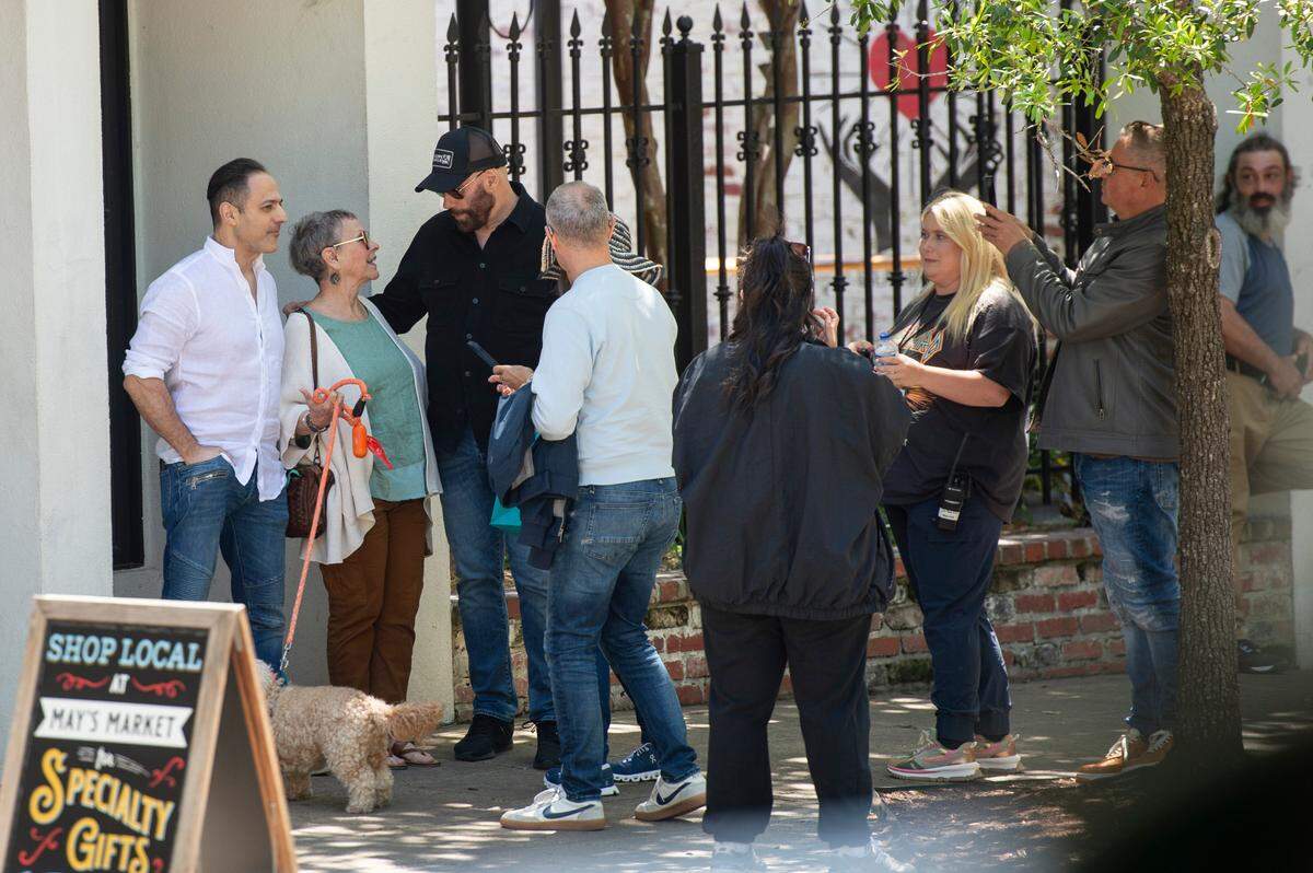 Actor John Travolta, center, takes photos with background actors on the set of Cash Out 3 during filming in Ocean Springs on Tuesday, April 8, 2025.
