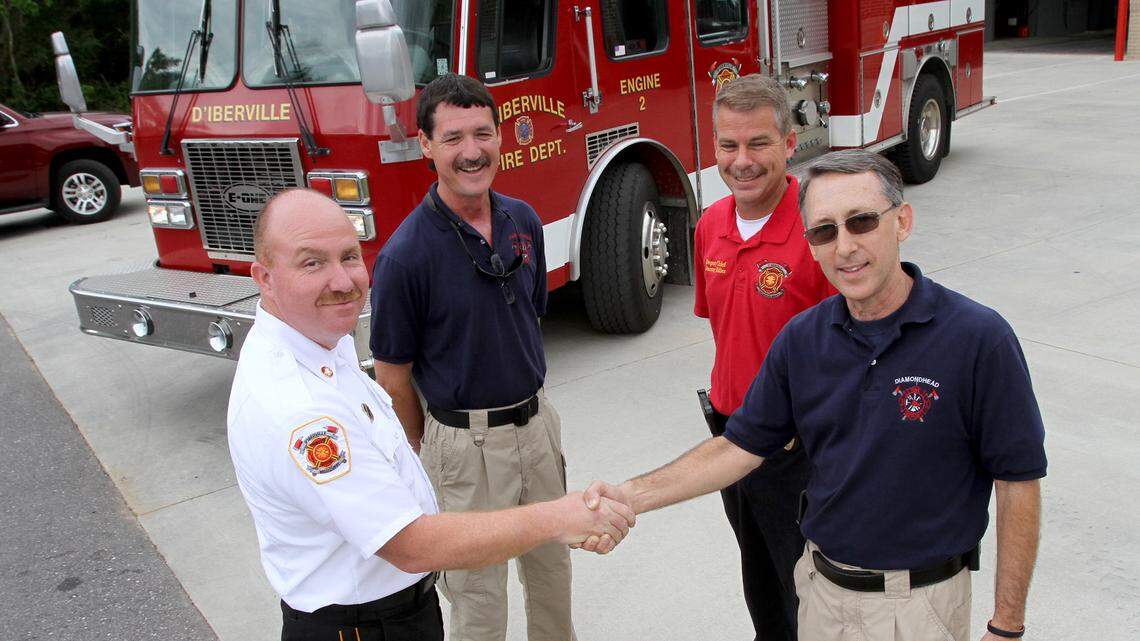 TIM ISBELL/SUN HERALD 
 The D'Iberville Fire Department donated one of its trucks to Diamondhead Fire Department, Thursday, May 12, 2017. From left are D'Iberville Fire Chief Gerald Smith, Diamondhead Lt. Brian Ladner, D'Iberville Assistant Chief Danny Miller and Diamondhead Fire Chief Jerry Dubuisson.