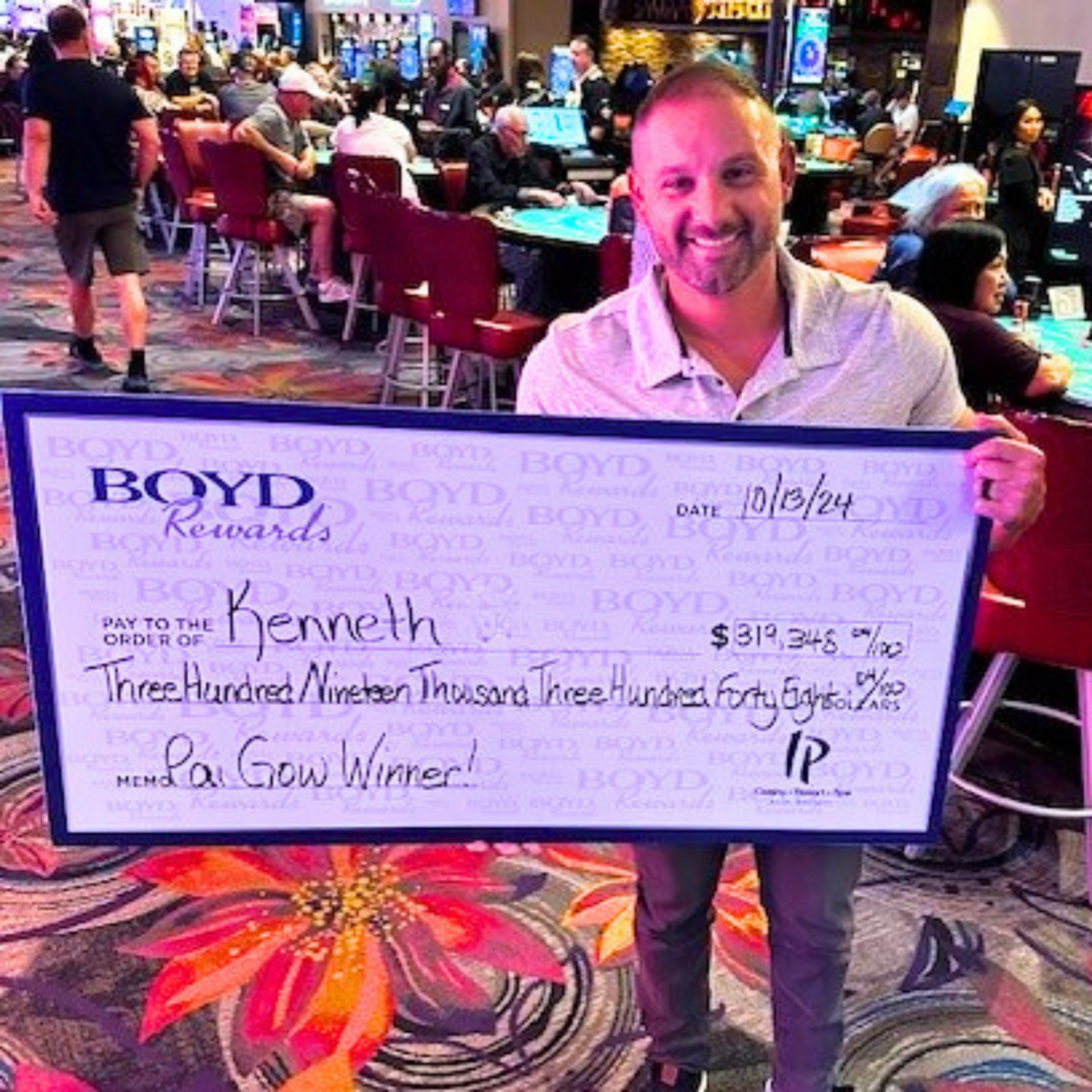 Kenneth, a player at IP Casino in Biloxi, holds up his check for more than $300,000 that he won playing Pai Gow Poker progressive.