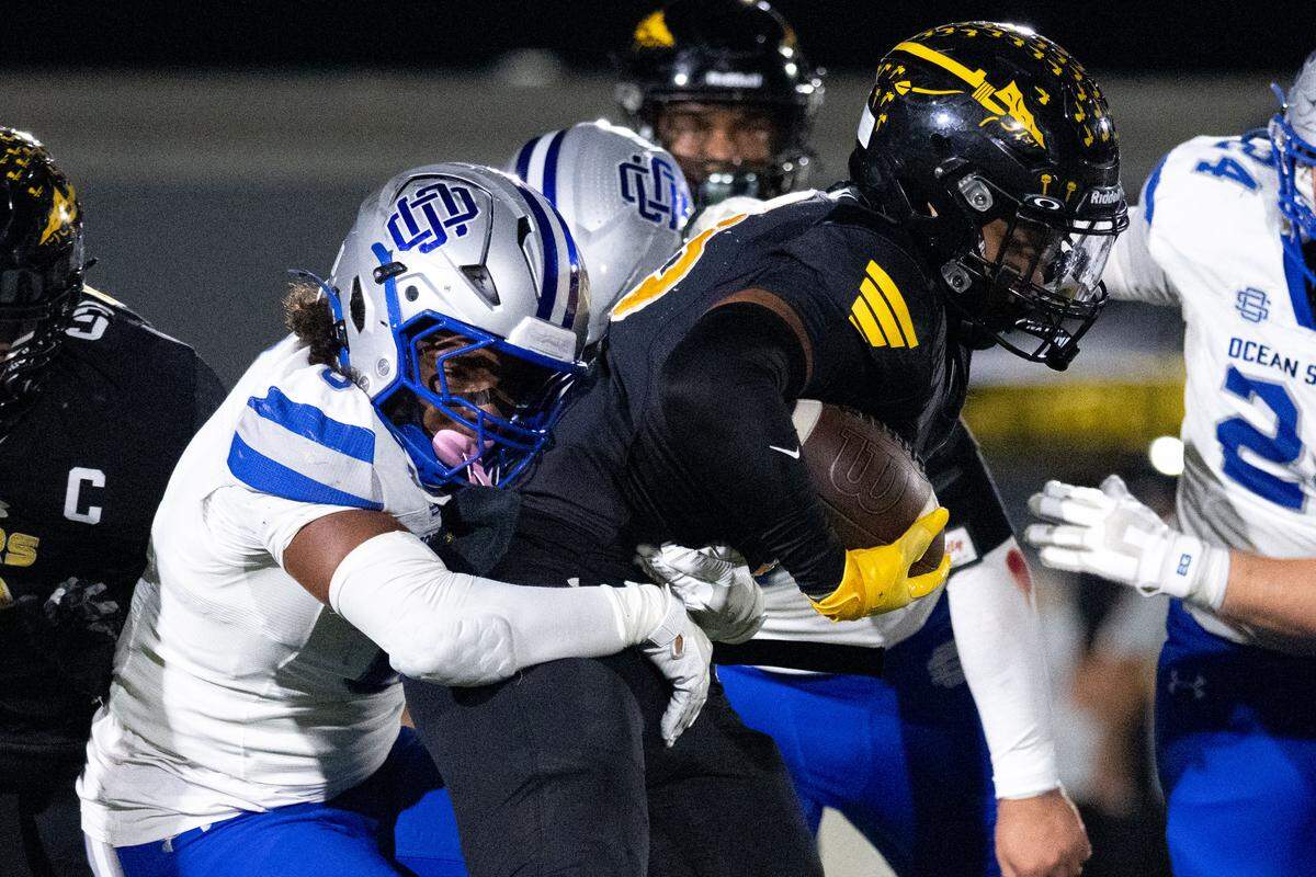 D’Iberville tight end Malakai Knight (18) is tackled by Ocean Springs linebacker Santiago Gaetan (0) during a football game at Buddy Singleton Field on Friday, Oct. 10, 2025.