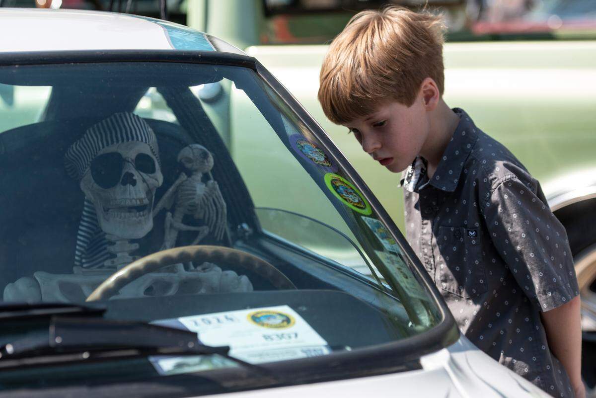 A spectator looks in the window of a vehicle during Cruisin’ The River City, a Cruisin’ The Coast event in Moss Point on Tuesday, Oct. 8, 2024.