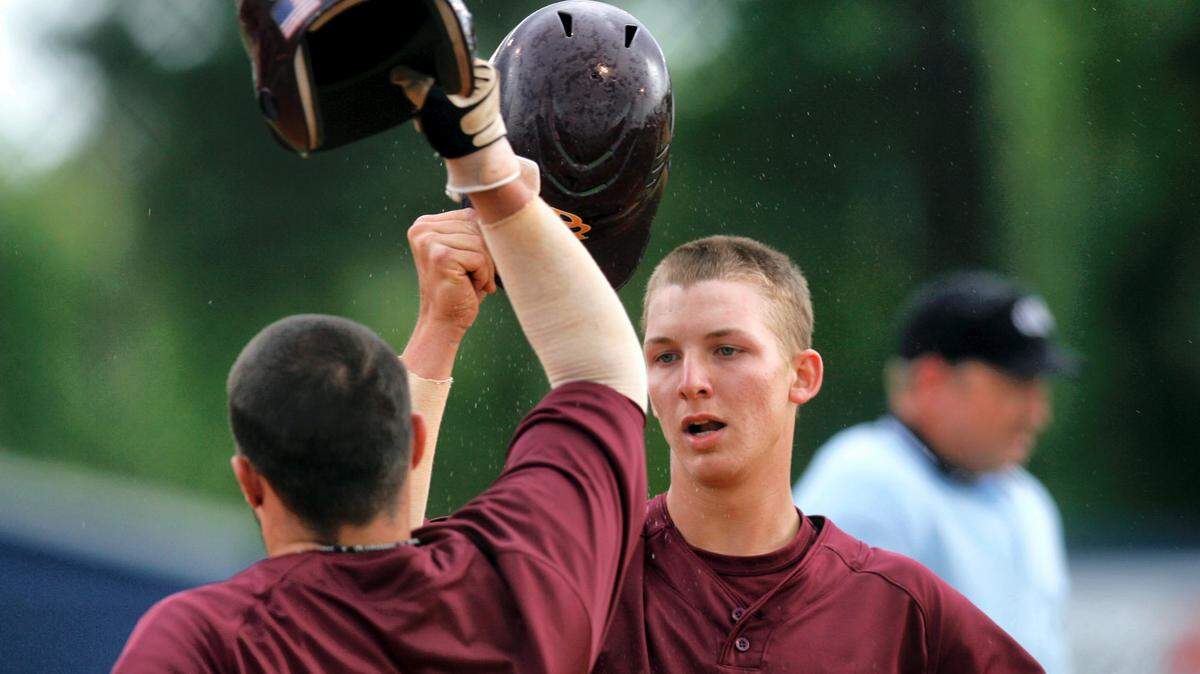 Pearl River’s Ashley Graeter (left) and Zach Farrar tap helmets after Graeter hit a two-run homerun against MGCCC.