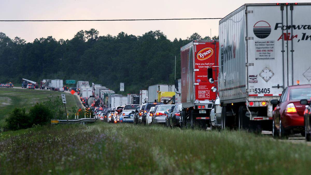 AMANDA McCOY/SUN HERALD 
 Traffic in the west bound lane of Interstate 10 near exit 57 slows to a near standstill after an accident caused an semi-truck to overturn into the median and lose its cargo of barrels of ether. The stretch of road between exits 50 and 57, which frequently back up because of heavy traffic and accidents, is being widened to six lanes by MDOT.