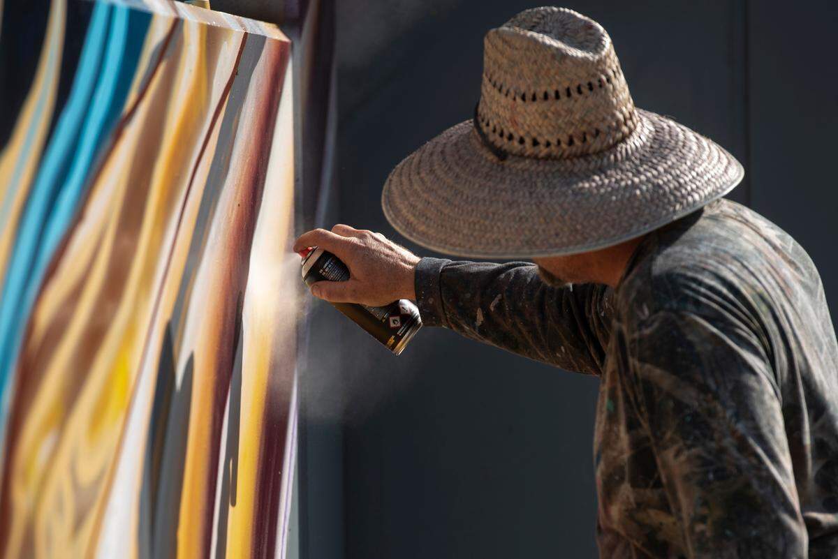 Artist Douglas Hoekzema, also known as Hoxxoh, works on a mural he is painting on the parking garage at the new OS 1515 development in downtown Ocean Springs on Tuesday, Oct. 29, 2024.