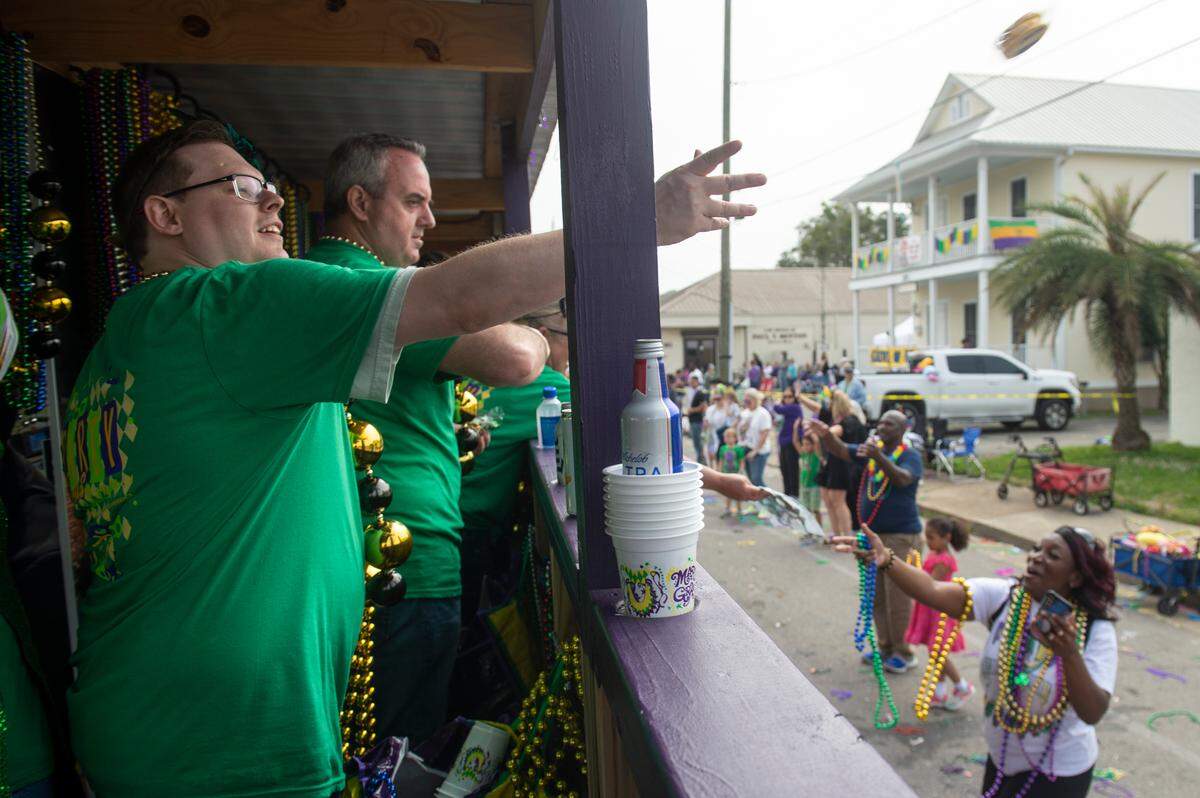 Float riders toss beads and Moon Pies from the BetMGM float during the Gulf Coast Carnival Association Mardi Gras parade in Biloxi on Tuesday, Feb. 21, 2023.