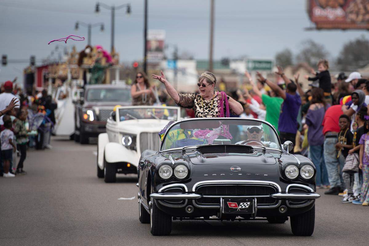 A float rider throws beads from a float during the Krewe of Gemini parade in downtown Gulfport on Saturday, Feb. 10, 2024.