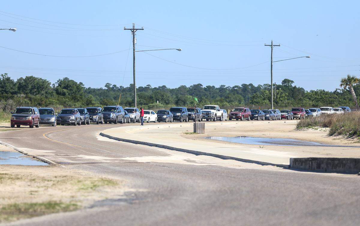 Cars line Highway 90 to check in before going through a mobile food pantry in the Silver Slipper parking lot in Hancock County during the Covid pandemic in April 2020.