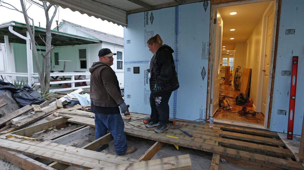 KATHY WILLENS/ASSOCIATED PRESSHabitat for Humanity employees Reynaldo and Anna Acosta work Oct. 27 on the deck of a heavily damaged one-story bungalow owned by a 91-year-old resident in Breezy Point, before the third anniversary of Superstorm Sandy in New York. The couple has worked exclusively on rebuilding homes damaged by the storm for nearly the entire three years, initially as volunteers and now as Habitat employees. 'No matter how much work we do,' says Anna Acosta, 'there's always more to do.'
