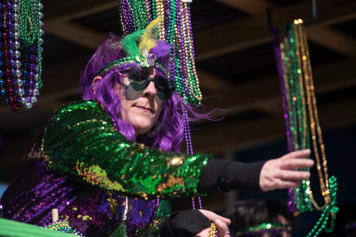 A float rider tosses beads to the crowd during the Krewe of Nereids Mardi Gras parade on Highway 90 in Bay St. Louis on Sunday, Feb. 12, 2023.