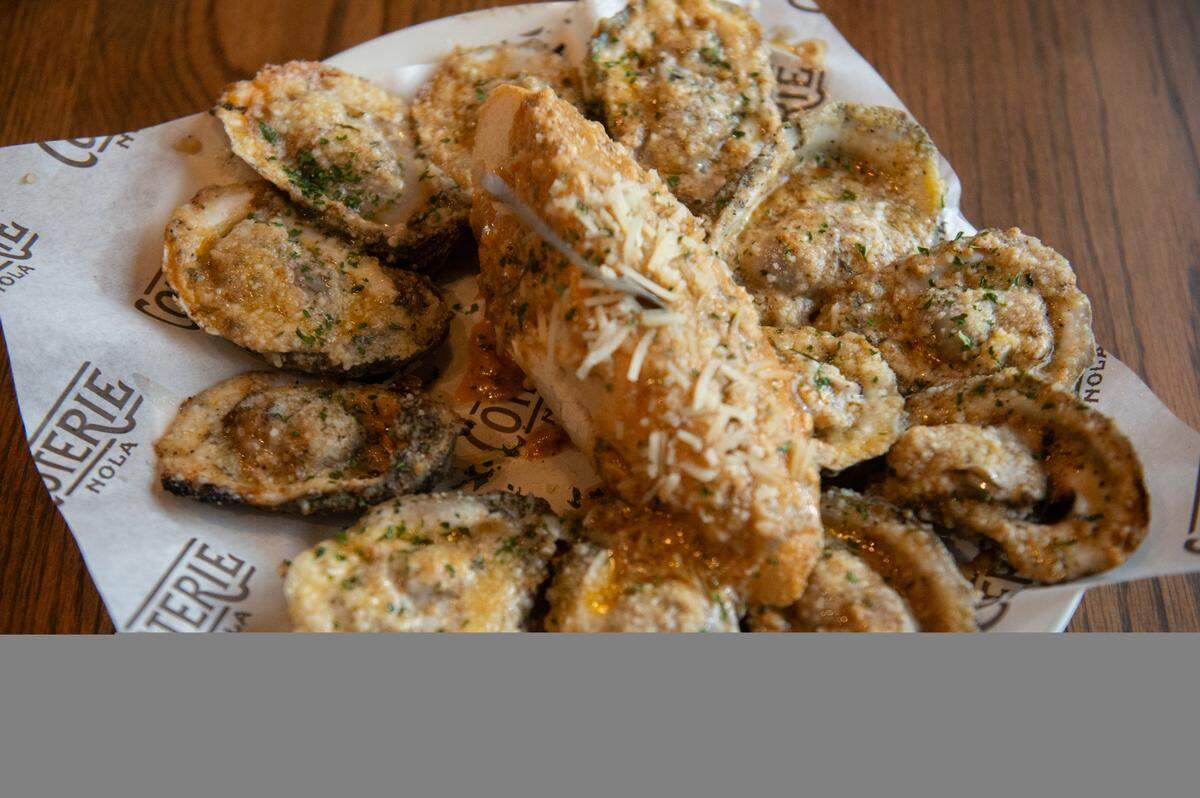 The chargrilled oysters, topped with a special blend of cheese and served with bread slices at Coterie Restaurant and Oyster Bar in Long Beach, which brings the tastes of New Orleans to the Coast.