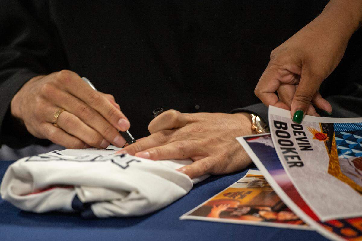 NBA star Devin Booker signs autographs before a ceremony for the retirement of Booker’s high school jersey at Moss Point High School in Moss Point on Saturday, Dec. 10, 2022.