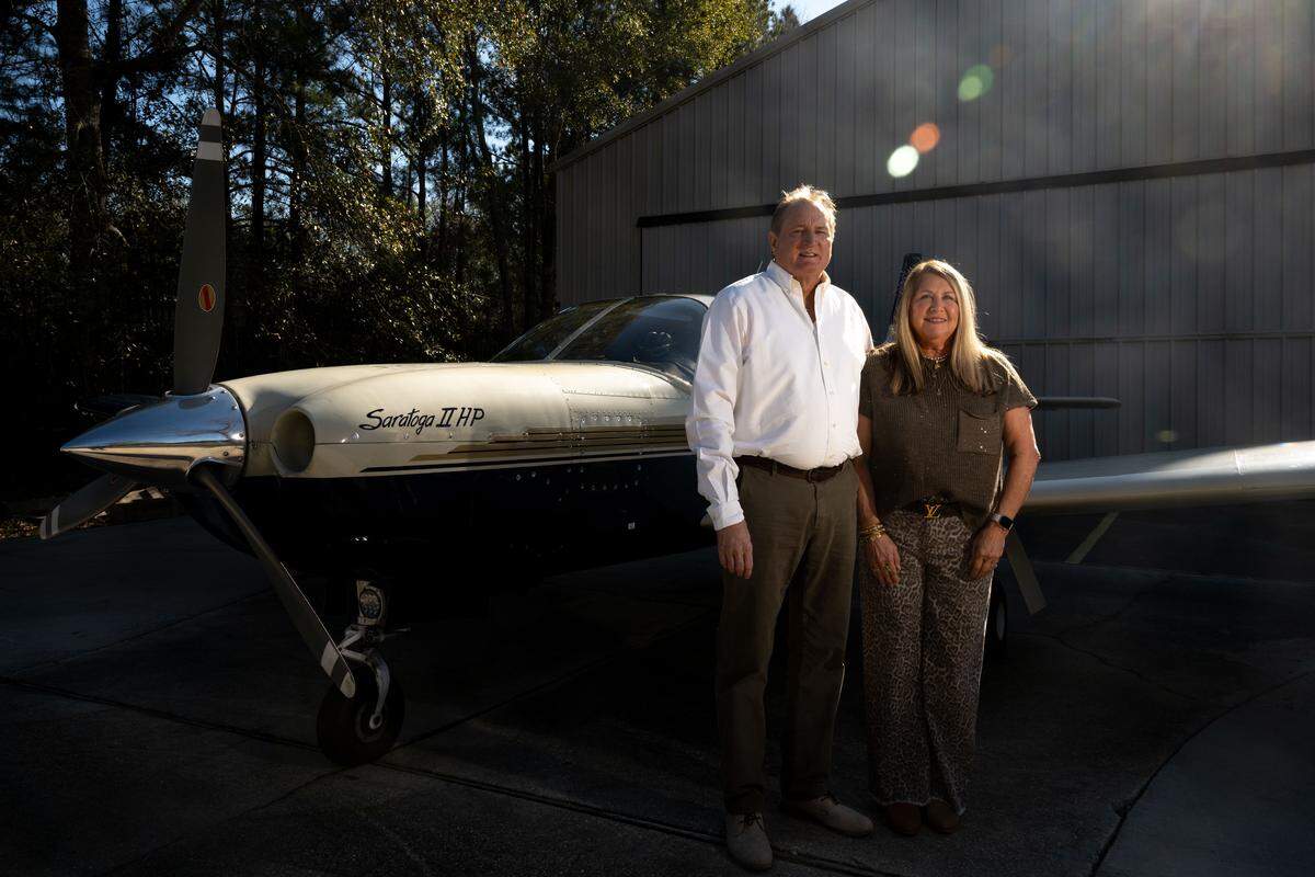 Neil and Pam Pickering pose in front of their airplane behind their house in Diamondhead on Friday, Jan. 16, 2026.