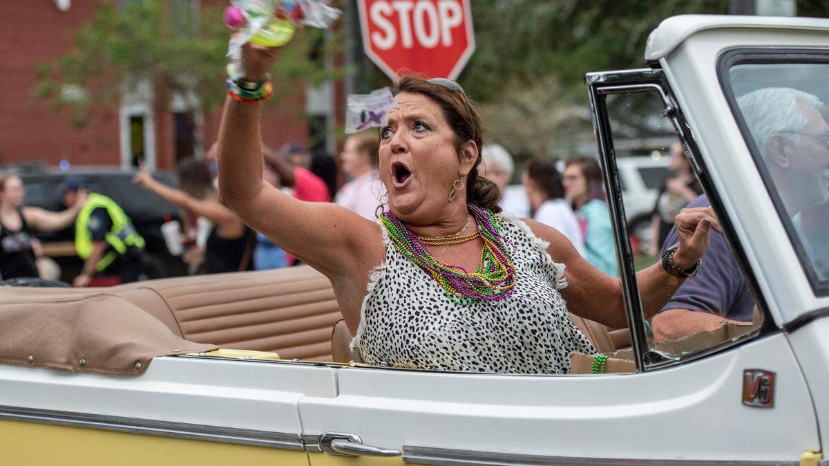 A woman tosses candy from a vintage convertible Jeep during the Long Beach Parade during Cruising’ the Coast in Long Beach on Monday, Oct. 4, 2021.