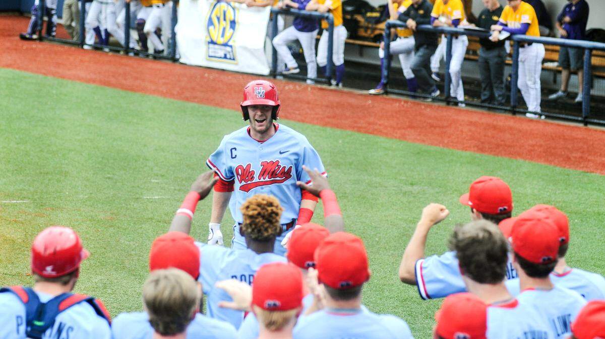 BRUCE NEWMAN/ASSOCIATED PRESS 
 Ole Miss outfielder J.B. Woodman (12) hits a two run home run against LSU and is congratulated by teammates on Saturday.