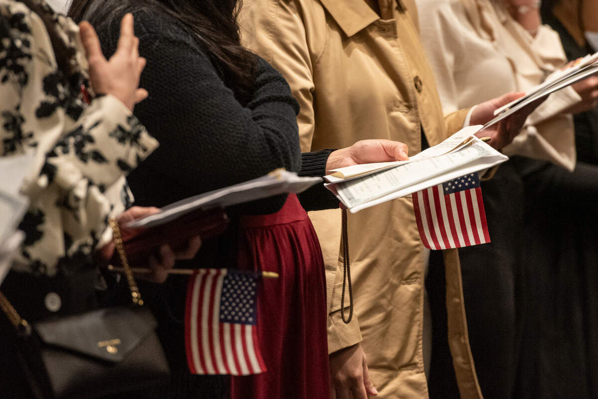 Newly naturalized American citizens do the pledge of allegiance during a naturalization ceremony at Dan M. Russell Courthouse in Gulfport on Thursday, Oct. 19, 2023.