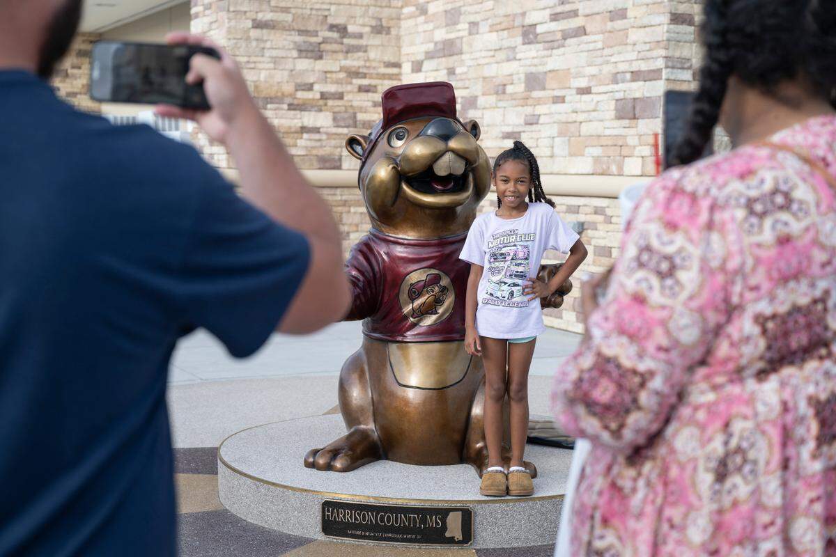 Customers take photos with the Buc-ee statue as the popular travel stop, Buc-ee’s, opened its first Mississippi location in Harrison County on Monday, June 9, 2025.