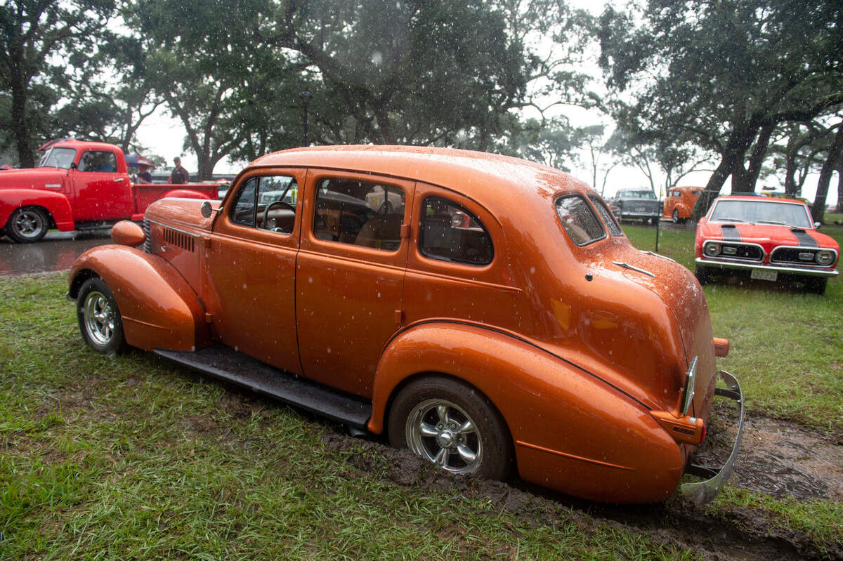 A car gets stuck in the mud as rain pours down on Centennial Plaza during Cruisin’ the Coast in Gulfport on Monday, Oct. 4, 2021.