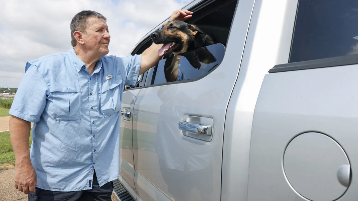 Frank Dungan pets his service dog near Barnett Reservoir in Ridgeland, Miss., Tuesday, May 10, 2022.