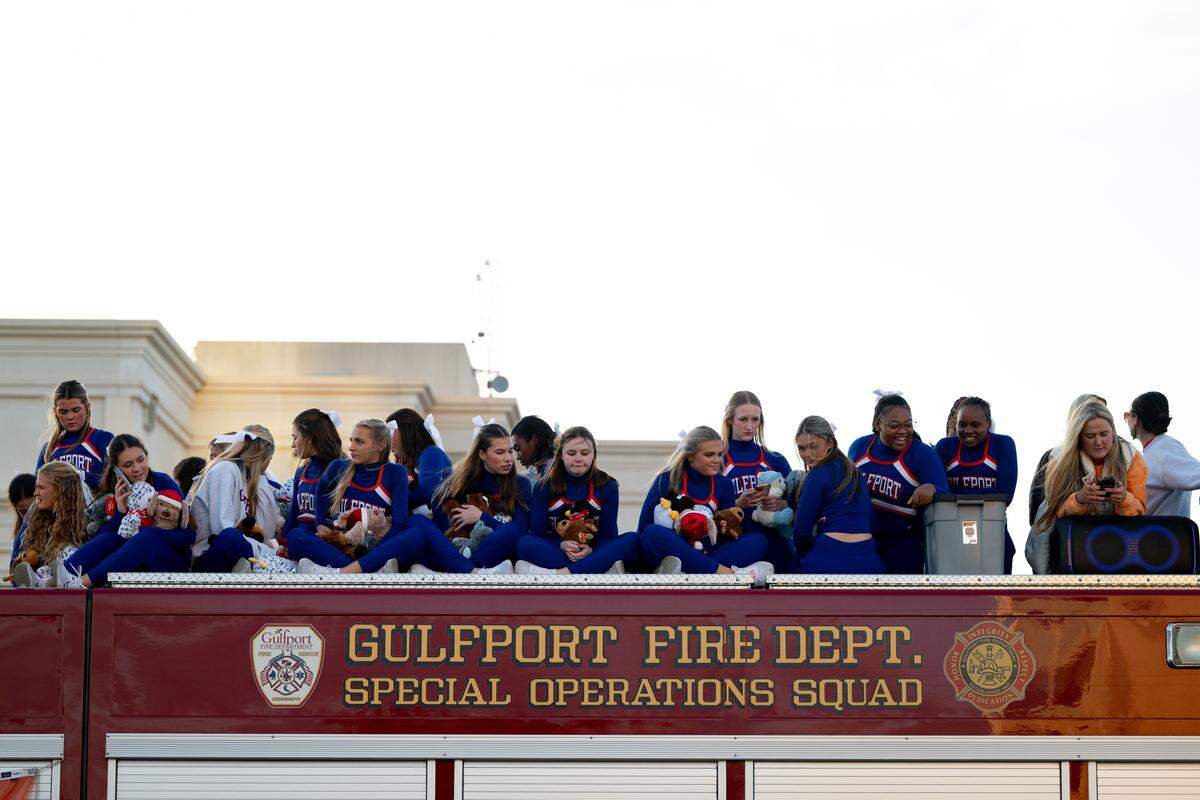 Gulfport cheerleaders sit on top of a firetruck during the Champions Christmas Parade in Gulfport on Monday, Dec. 8, 2025.
