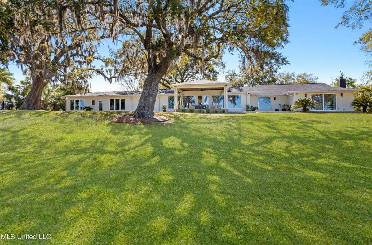 The 5,000 square foot home sits on an acre of waterfront land with old oak trees on the Back Bay of Biloxi.
