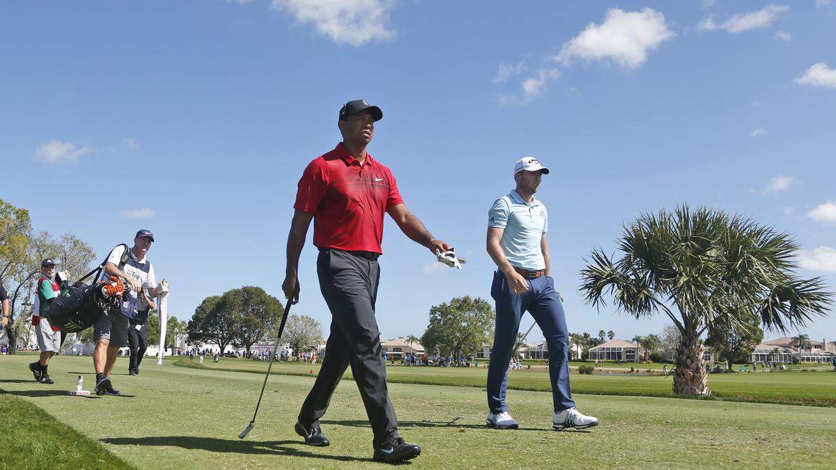 Tiger Woods, center, and Sam Burns, right, walk off the tee on the fifth hole during the final round of the Honda Classic golf tournament, Sunday, Feb. 25, 2018, in Palm Beach Gardens, Fla.