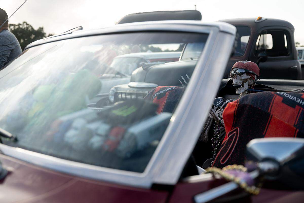 Boney, a prop skeleton, sits in a vintage car during the Long Beach Cruisin’ The Coast Parade.