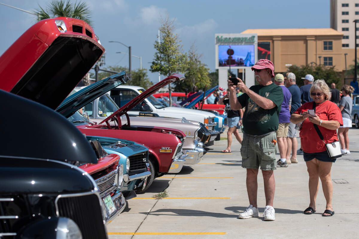Spectators photograph cars at Paradise Pier during Cruisin’ the Coast on Tuesday, Oct. 3, 2023.
