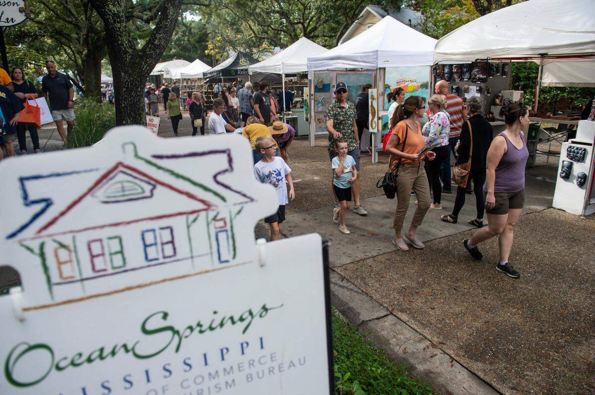 People walk among tents selling art along Washington Avenue during the Peter Anderson Festival in Ocean Springs on Sunday, Nov. 6, 2022.