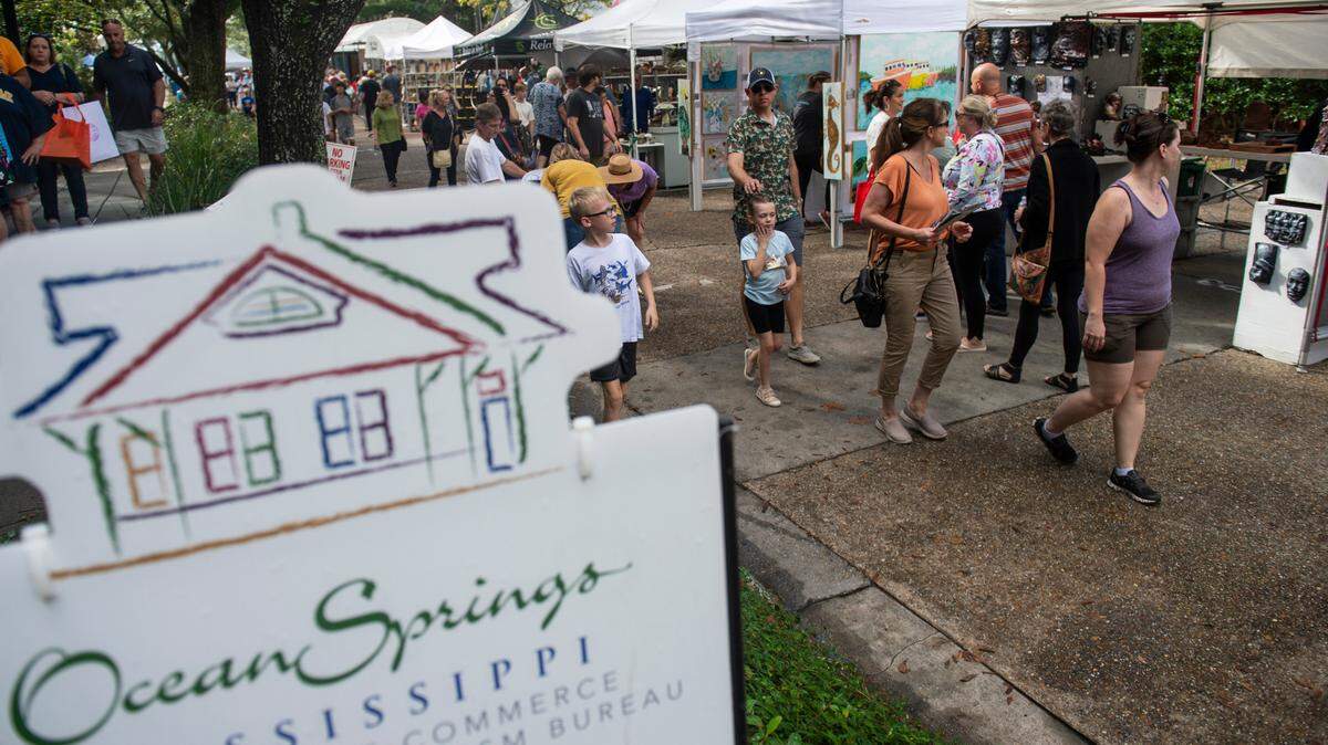 People walk among tents selling art along Washington Avenue during the Peter Anderson Festival in Ocean Springs on Sunday, Nov. 6, 2022.