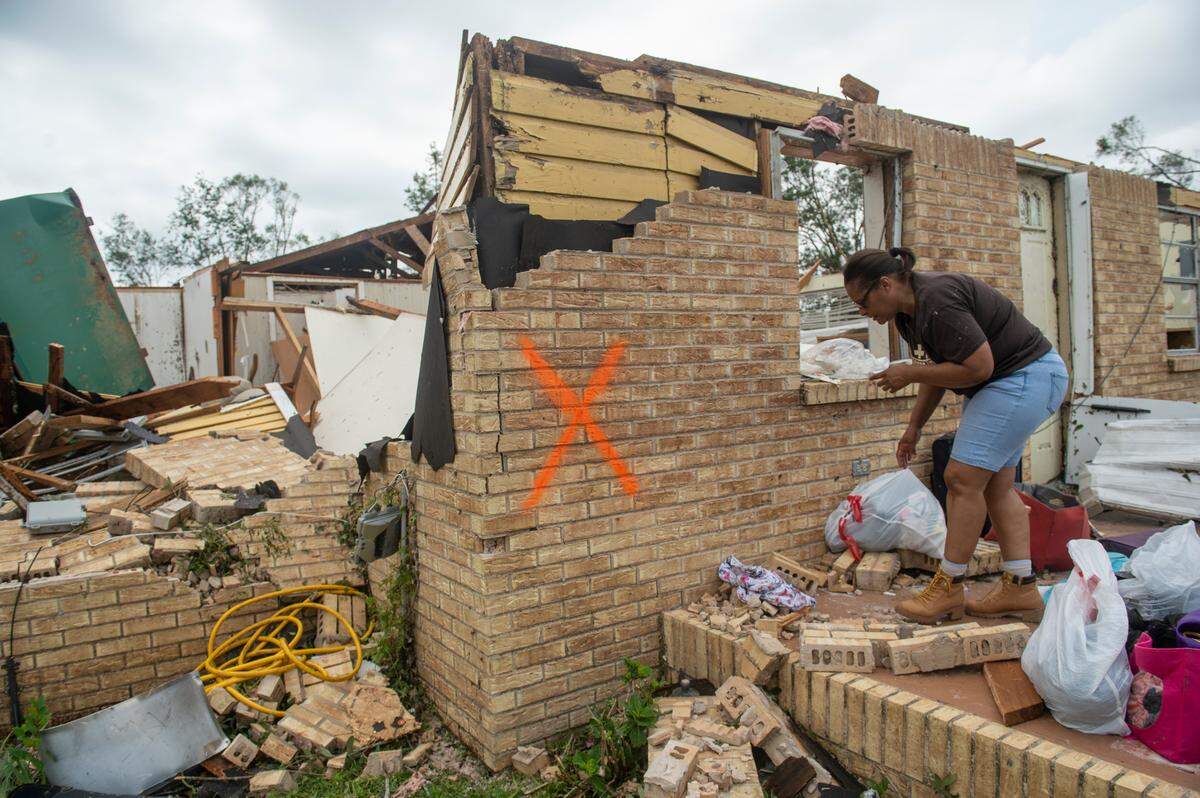 Myra Howard cleans out her aunt’s damaged home in Moss Point on Tuesday, June 20, 2023, after a tornado tore through the town on Monday.