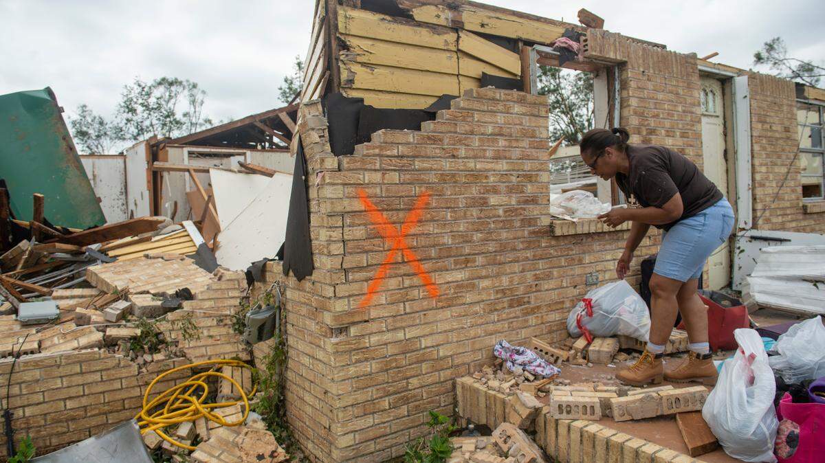 Myra Howard cleans out her aunt’s damaged home in Moss Point on Tuesday, June 20, 2023, after a tornado tore through the town. Storm damage intensified by climate change means Jackson County and other coastal communities, along with those subjected to wild fires, have the highest insurance nonrenewal rates in the country, a federal report shows.
