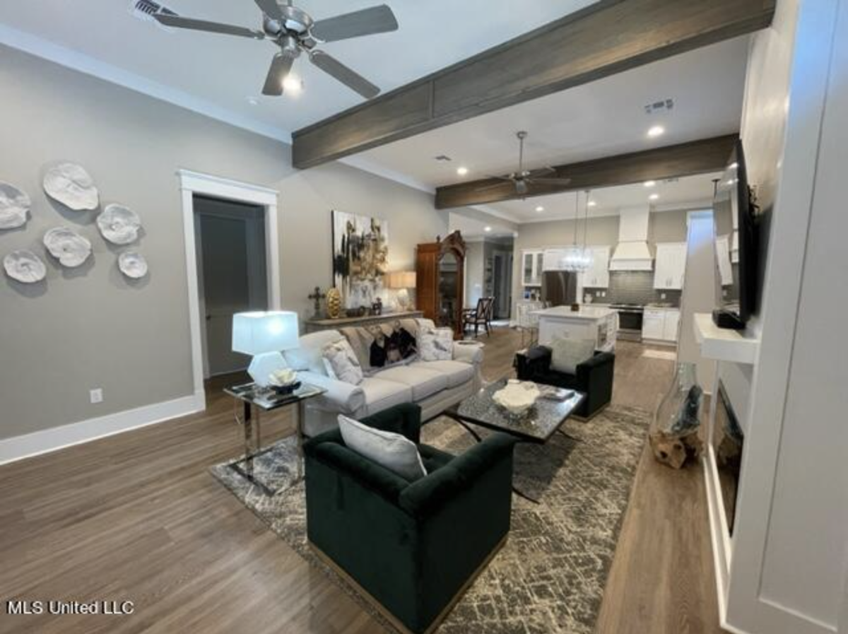 A patio home listed at The Courtyards at Dunbar in Bay St. Louis features an open-concept living area with custom window treatments and vinyl plank flooring. It also has a split bedroom plan with an oversize master bedroom, two additional bedrooms and two baths.