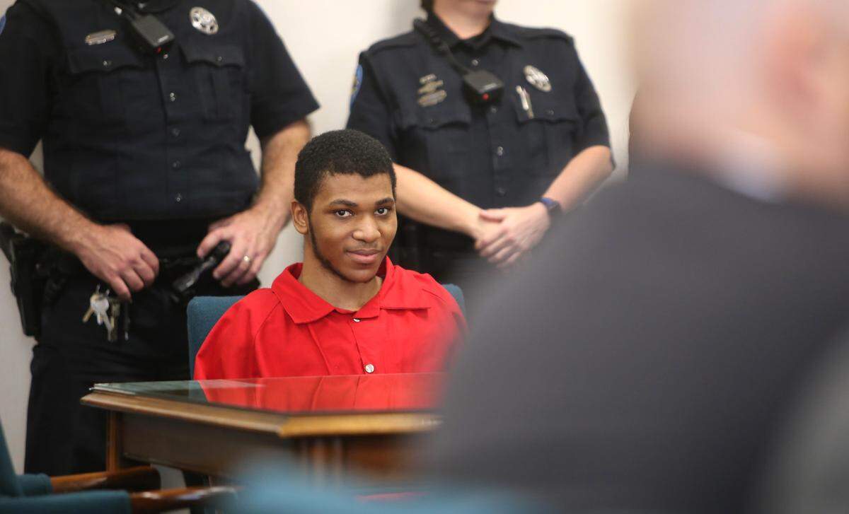 Darian Atkinson, a 19-year-old Biloxi man accused of fatally shooting Biloxi police officer Rocert McKeithen, smiles in court as he is seated for a preliminary hearing. Atkinson faces a capital murder charge and could face the death penalty if convicted.