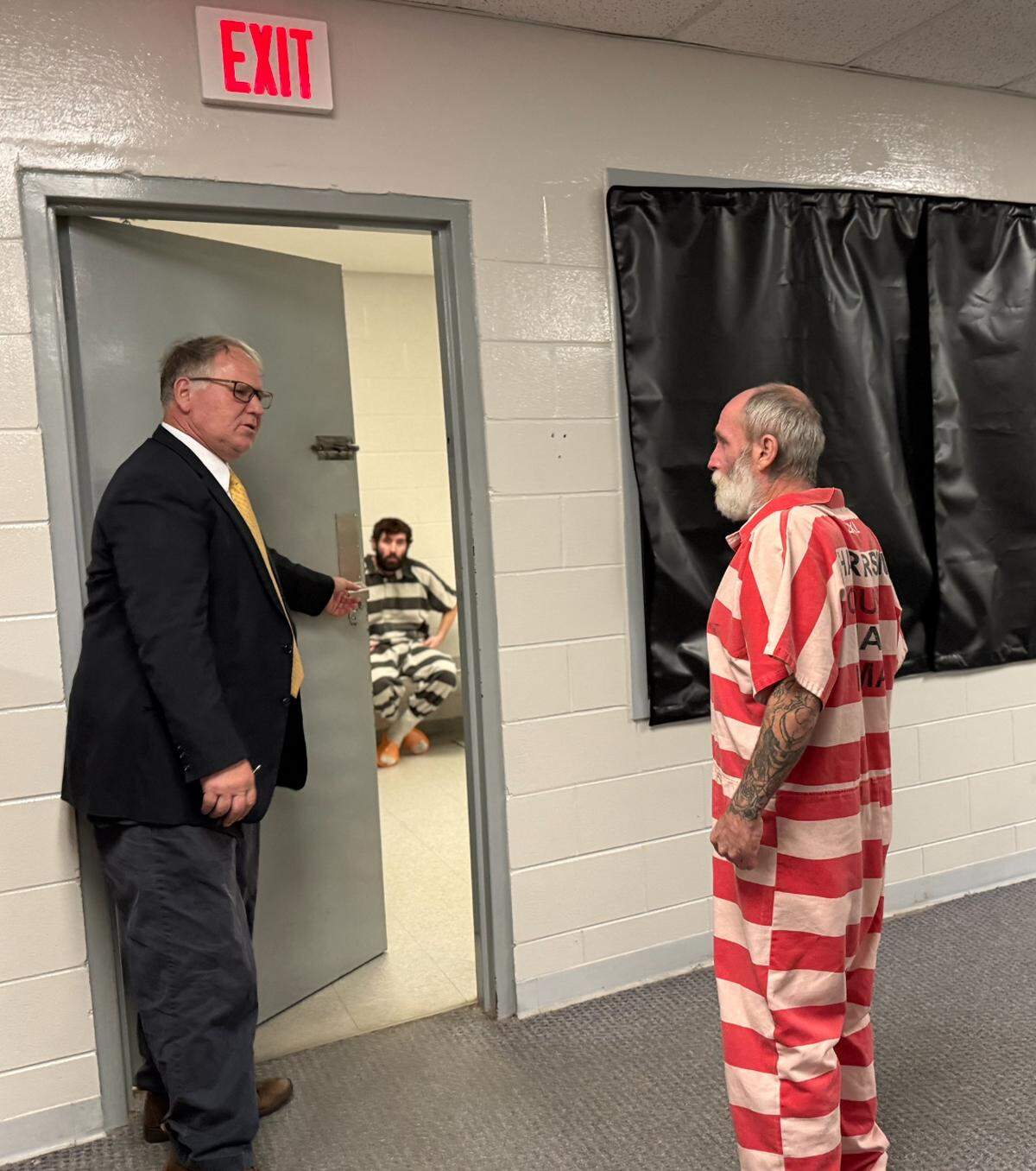 Floyd Charles Guy, 51, talks to his attorney, Phil Wittmann, in the Harrison County jail after his preliminary hearing on a charge of attempted murder. Guy is accused of stabbing his roommate.
