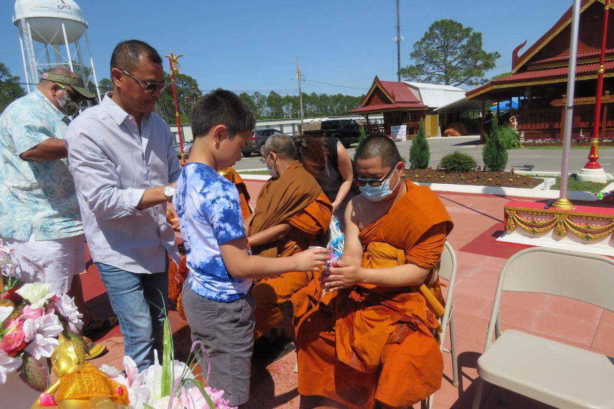 Festival attendees pour water on the monks at Wat Budhametta Mahabaramee in Gautier on April 11, 2021. During Songkran, water symbolizes the washing away of wrongdoing and bad things from the past year.
