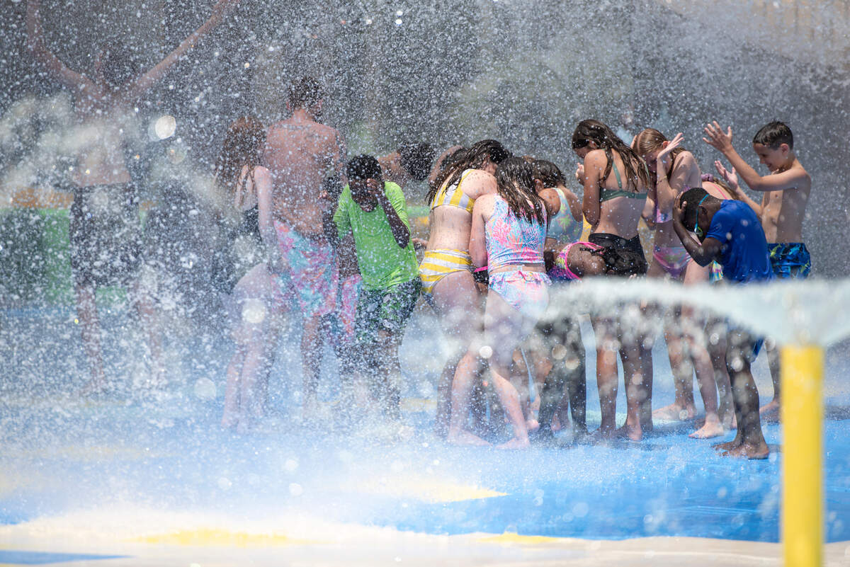 Kids stand under the massive bucket as it dumps water at Serengeti Springs at the Hattiesburg Zoo, a new waterpark that opened in May, on Wednesday, June 5, 2024. The large bucket dumps water every four minutes.