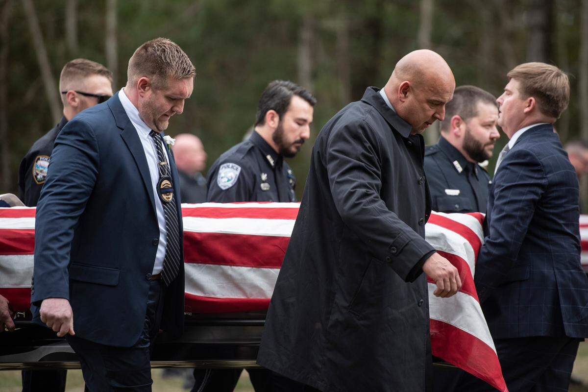 Law enforcement officers carry the caskets of Bay St. Louis police officers Sgt. Steven Robin and Branden Estorffe following their funeral at the Bay St. Louis Community Center in Bay St. Louis on Dec. 21, 2022. 
