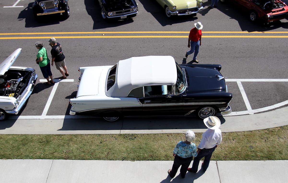 Car enthusiasts walk along Beach Boulevard in downtown Bay St. Louis during Cruisin The Coast on Thursday, October 11, 2012.