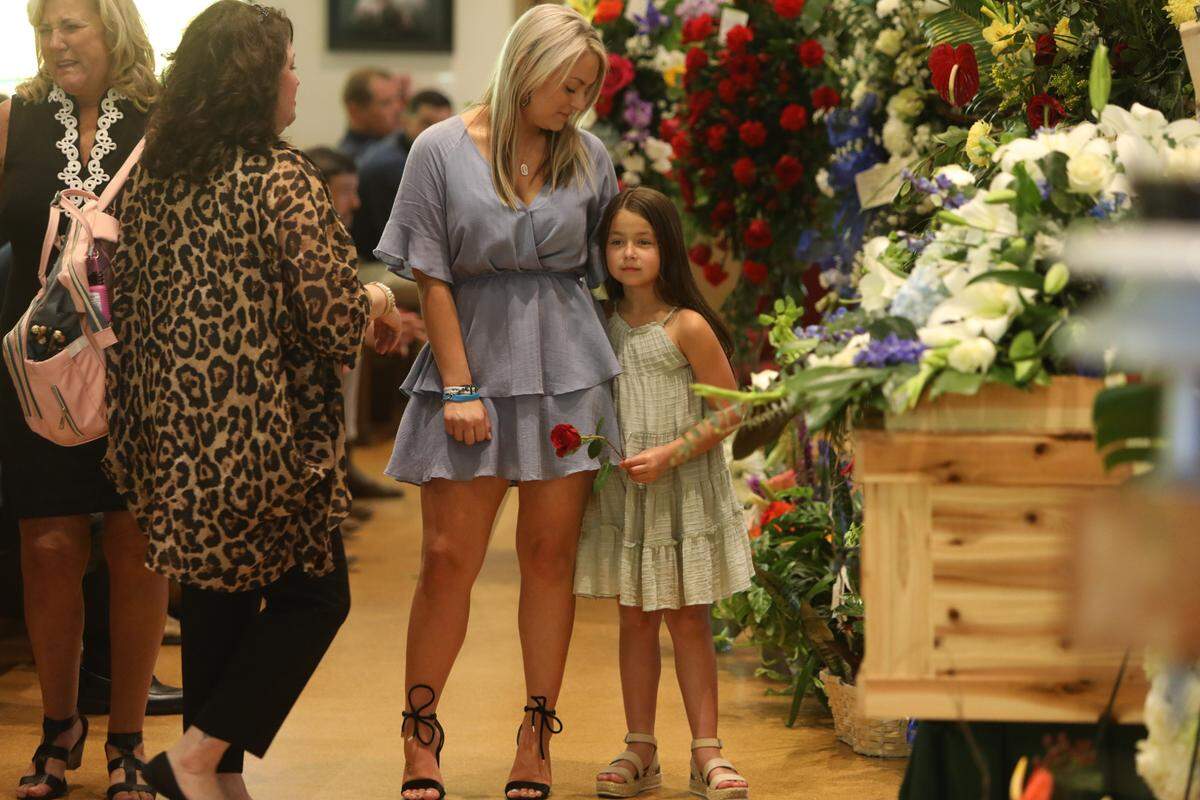 Anistyn Hoda, 8, hugs mother Cassie Lassabe during funeral services for Lassabe’s partner, Cayce Seal, on July 1, 2021, at St. Clare Catholic Church in Waveland.