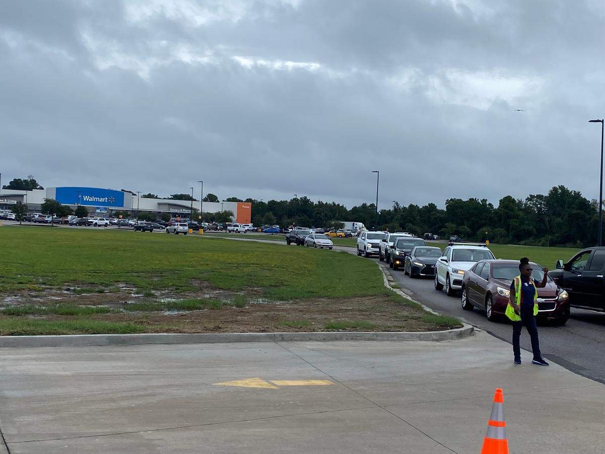 Under stormy skies, lines were long for a time Tuesday at the Pass Christian Walmart, where a security official directs drivers in intervals for gas at the pumps. Inside, the store is packed with people stocking up in water, snacks, batteries and other supplies. The wait returned to normal by 2 p.m.