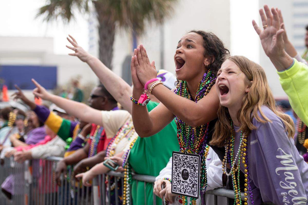 Parade watchers catch beads and other throws during the Gulf Coast Carnival Association Mardi Gras parade in Biloxi on Tuesday, March 4, 2025.