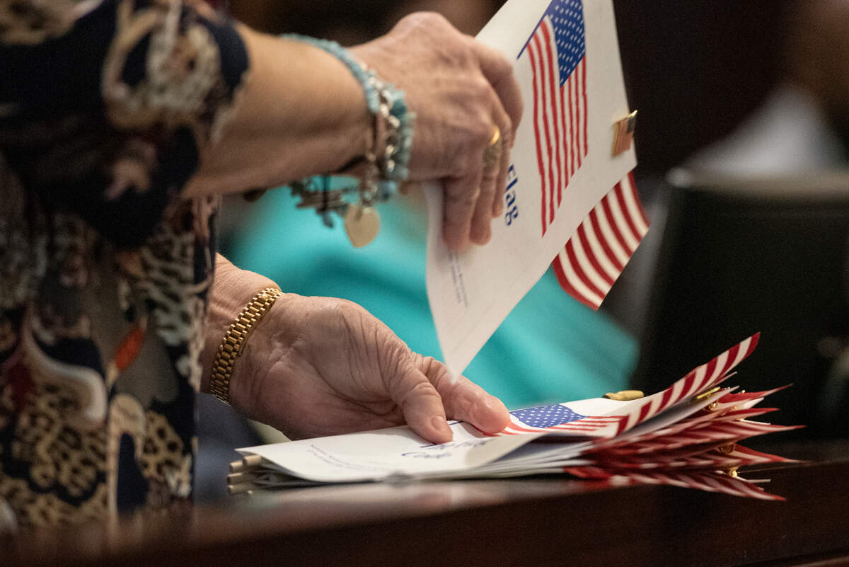 Members of daughters of the American Revolution hand out American flags and pins to newly naturalized American citizens during a naturalization ceremony at Dan M. Russell Courthouse in Gulfport on Thursday, Oct. 19, 2023.