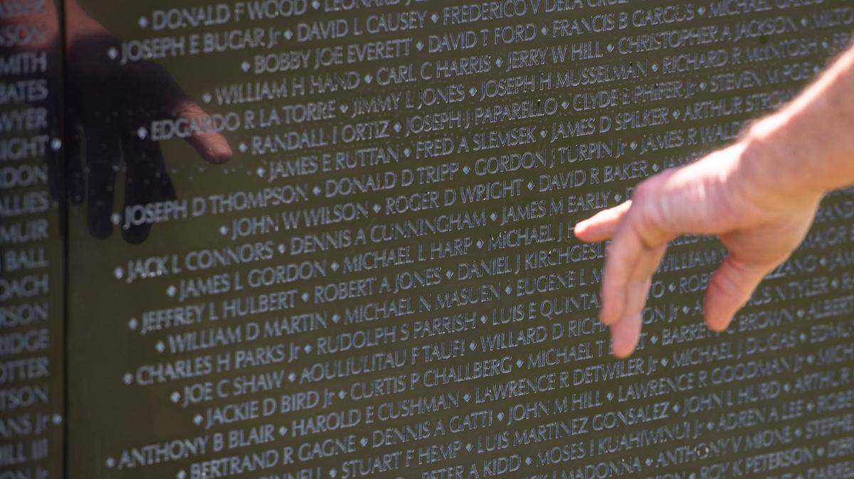 Visitors look at names on The Wall That Heals, a traveling three-quarter scale replica of the Vietnam Veterans Memorial in D.C., while it is on display at the D’Iberville Sports Complex in D’Iberville on Thursday, April 10, 2025.