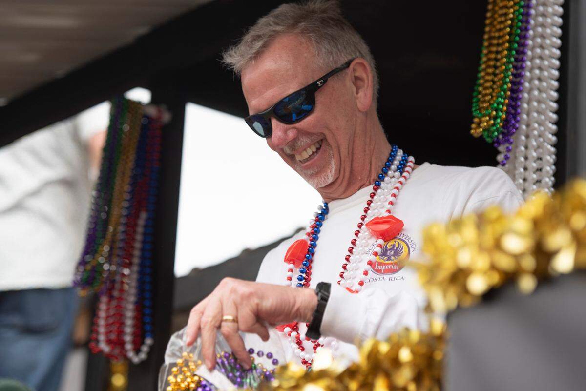 A float rider throws beads to the crowd during the Gulf Coast Carnival Association Mardi Gras parade in Biloxi on Tuesday, March 4, 2025.