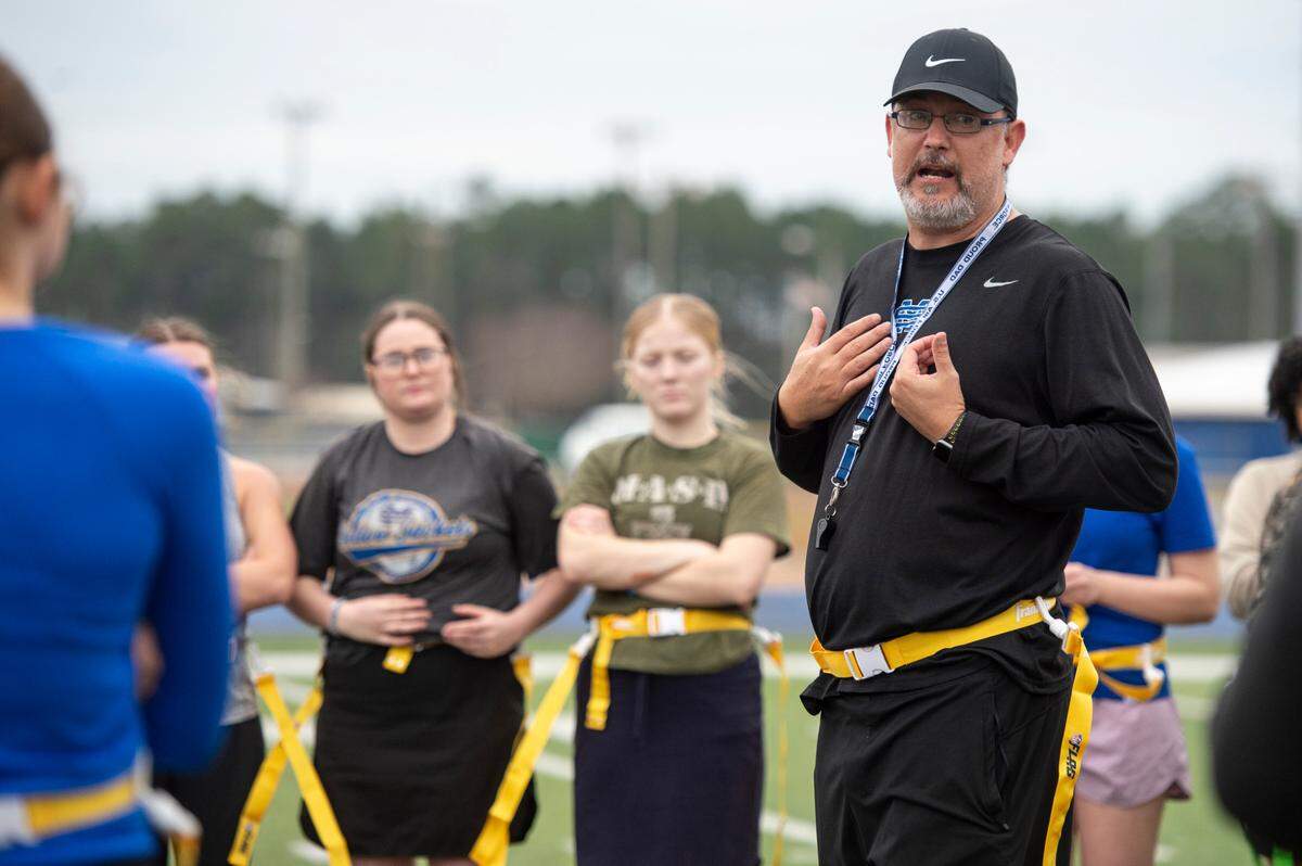 Coach Charlie Pavlus instructs girls during a tryout for flag football at St. Martin High School on Tuesday, Feb. 18, 2025.