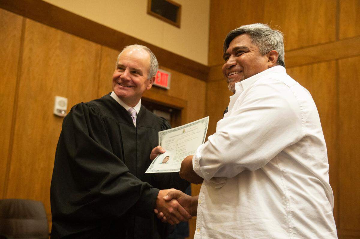 U.S. Judge Halil Ozerden presented naturalization documents to each new American citizen during a naturalization ceremony at Dan M. Russell Jr. Federal Courthouse in Gulfport on Friday, Oct. 7, 2022.