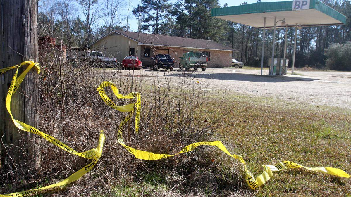 Discarded police tape sits near McLemore Gun Shop in the Henleyfield community north of Picayune on Sunday Jan. 24, 2016. The owner of the store and his son were shot to death there by another father and son on Saturday, Jan. 23, 2016.