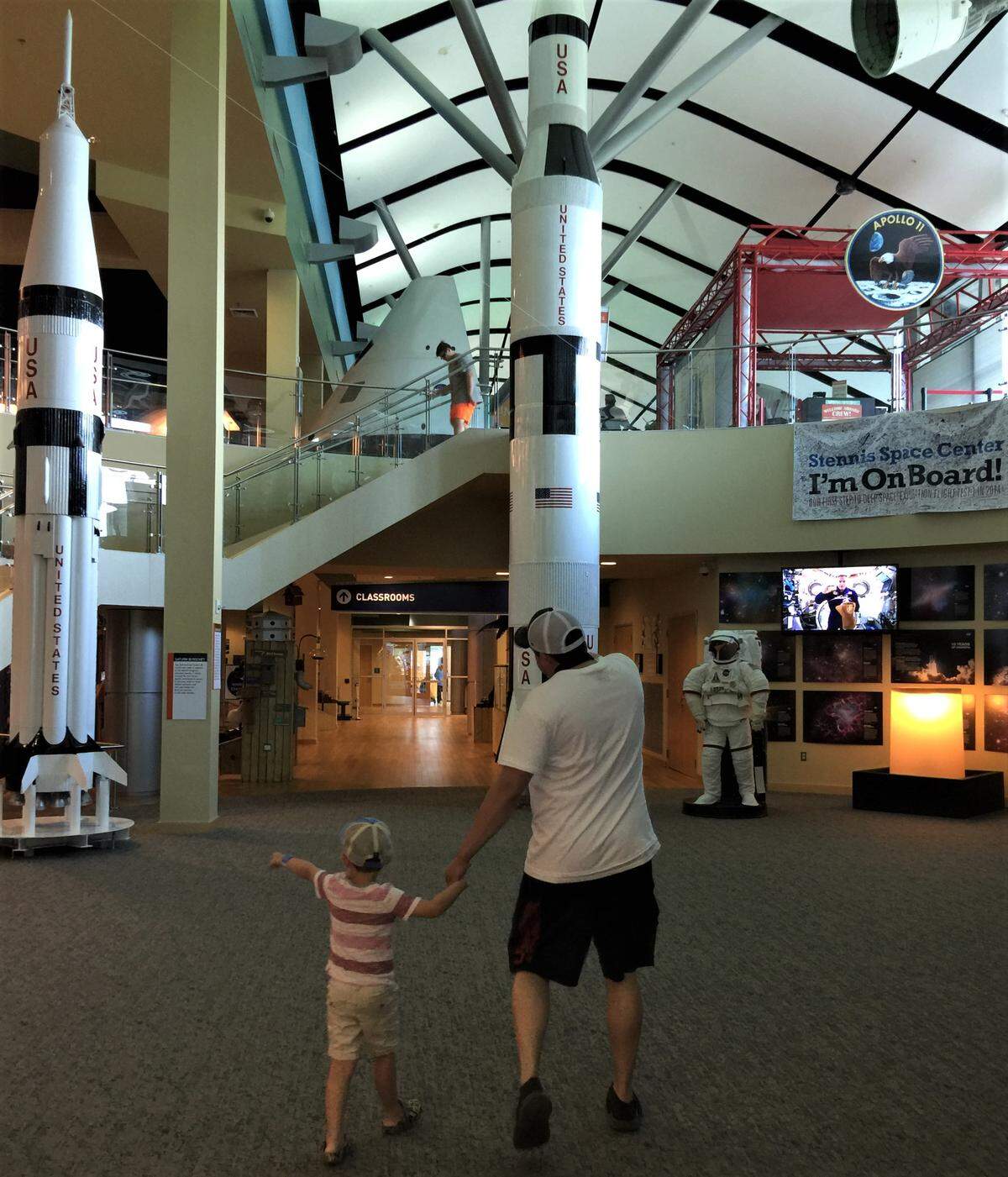 A father and son point to the rockets that await inside Infinity Science Center in Hancock County. The center has many Apollo displays, including the Apollo 4 capsule, the massive Saturn V rocket and Biloxi astronaut Fred Haise’s spacesuit from Apollo 13.