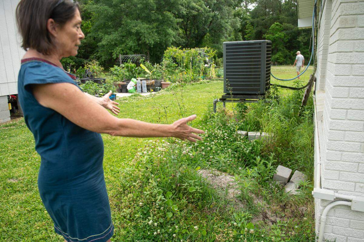 Tami Curtis Guy points out a hole behind her home in Bay St. Louis on Monday, April 29, 2024, where a resistance test had been done. The resistance test was required before officials would approve a FEMA grant to elevate the house.