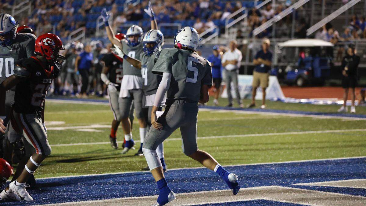 Ocean Springs Greyhounds quarterback Brayson Hubbard (5) scores in overtime during the Ocean Springs vs Clinton football game at Hugh Pepper Field, Ocean Springs, MS, Thursday, August 25, 2021.